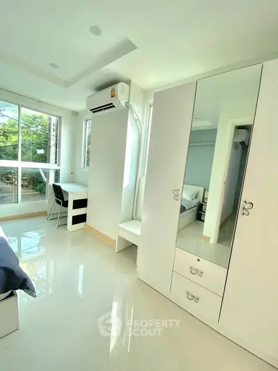 Bright and modern bedroom with large windows and sleek furniture