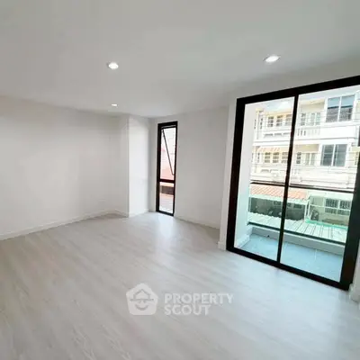 Spacious modern living room with large windows and balcony access