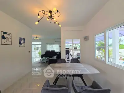 Modern dining area with stylish lighting and large windows overlooking a scenic view.