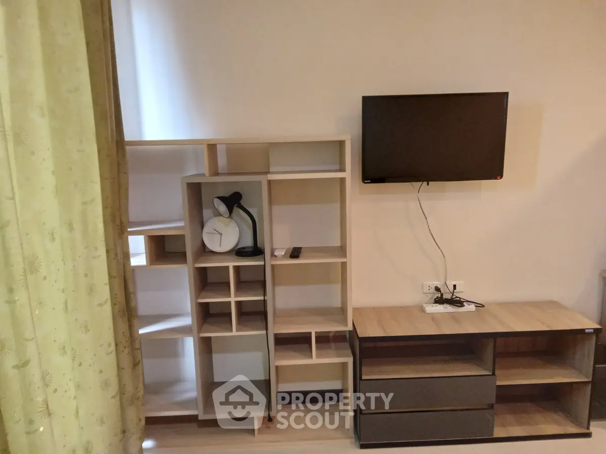 Modern living room with stylish shelving and wall-mounted TV, perfect for cozy urban living.
