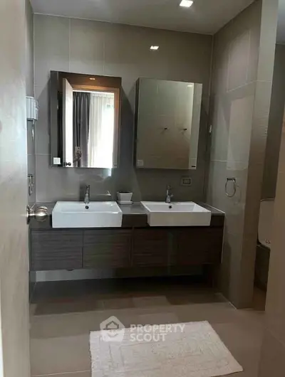 Modern bathroom with dual sinks and sleek cabinetry in a stylish apartment.