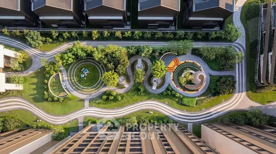 Stunning aerial view of modern residential complex with lush gardens and winding pathways.