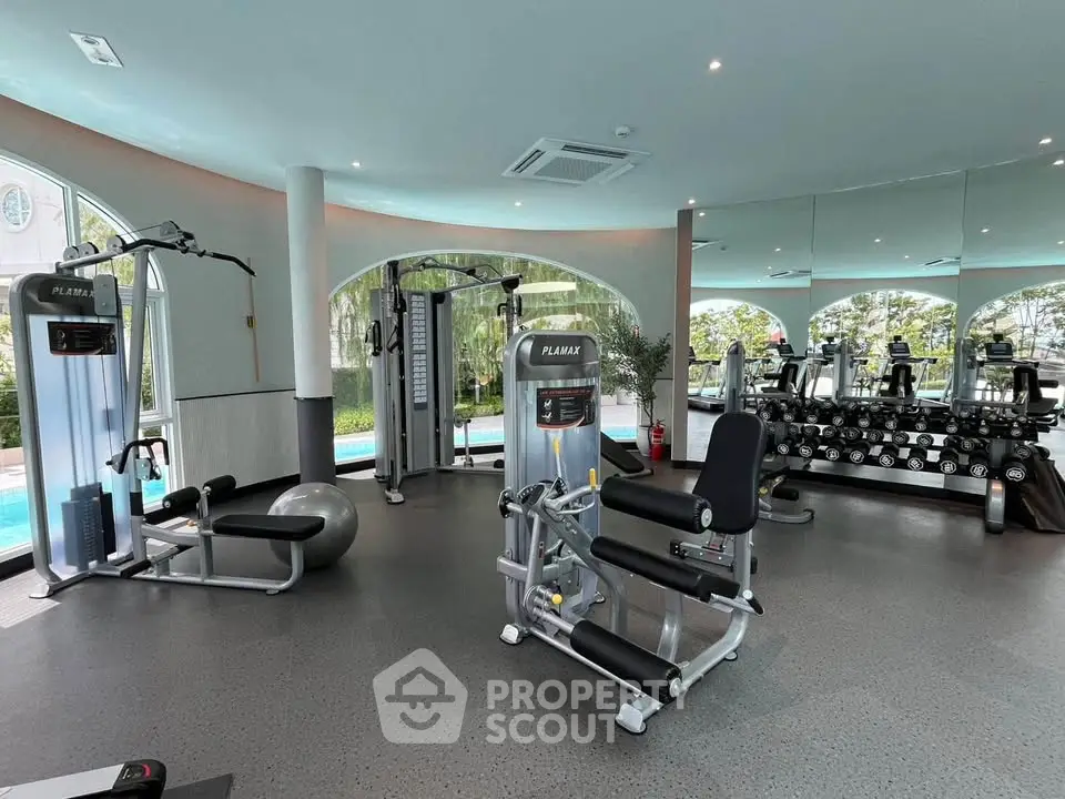 Spacious modern gym with state-of-the-art equipment and pool view