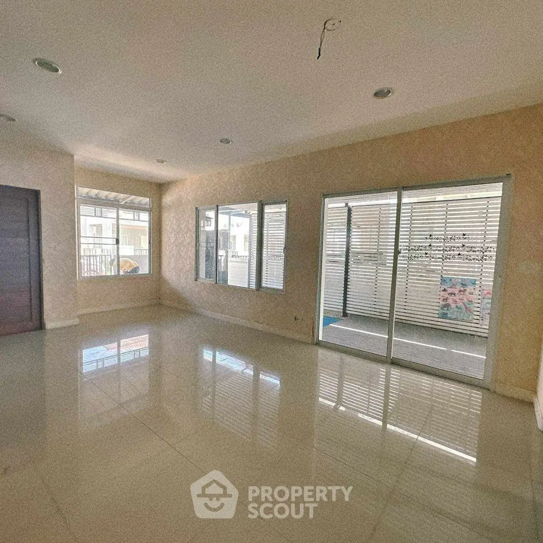Spacious living room with large windows and sliding glass doors for natural light.