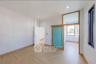 Spacious modern interior with wooden flooring and large windows for natural light.