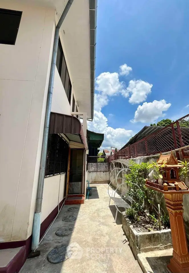 Charming exterior view of a residential property with clear blue skies and garden area.