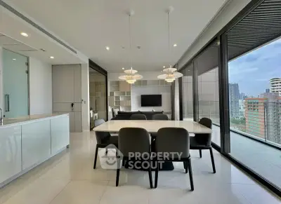 Modern open-plan living and dining area with city view, sleek furniture, and large windows.