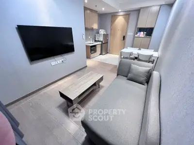 Modern living room with sleek furniture and open kitchen layout in a stylish apartment.