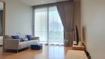 Spacious living room with modern decor and large windows offering city views.