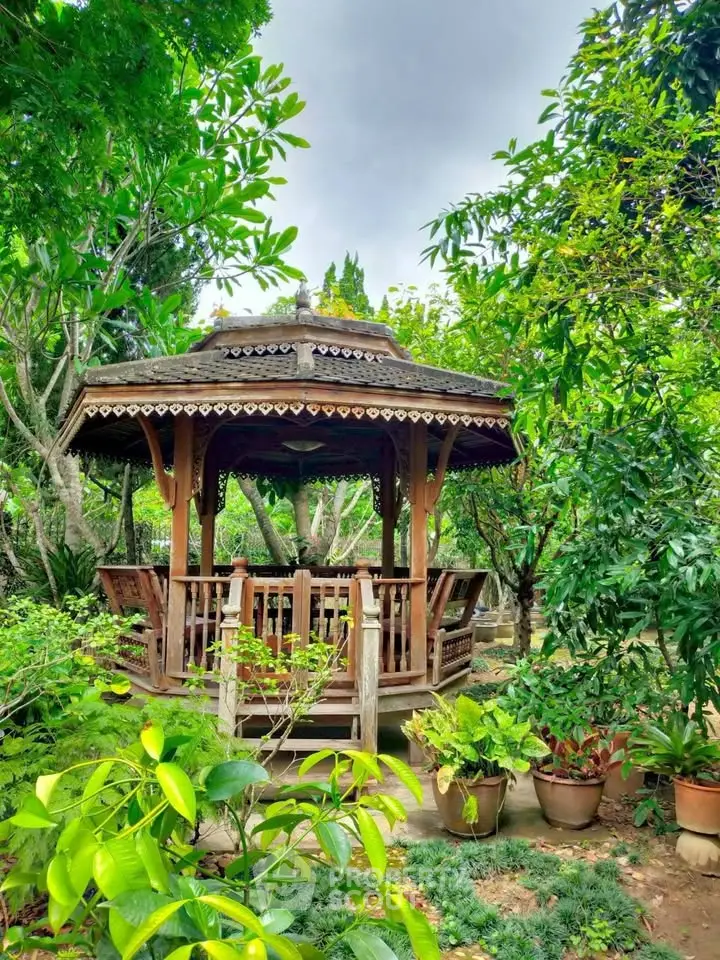 Charming wooden gazebo nestled in lush garden setting, perfect for relaxation and outdoor enjoyment.