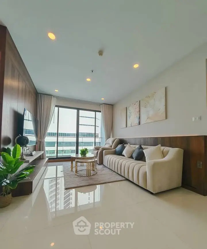 Spacious modern living room with large windows and elegant decor in a high-rise apartment.