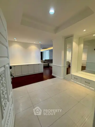 Spacious entryway leading to a stylish living room with elegant decor and modern lighting.