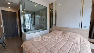 Modern bedroom with glass-enclosed bathroom and stylish decor in a luxury apartment.