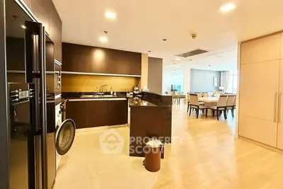 Spacious open-layout kitchen and dining area with modern appliances and elegant wooden flooring.