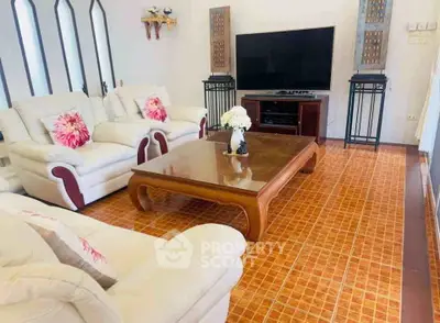 Spacious living room with elegant furniture and large TV, perfect for relaxation and entertainment.