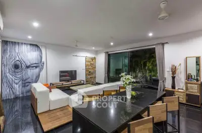 Modern living room with open layout and stylish decor, featuring a large mural and sleek furniture.