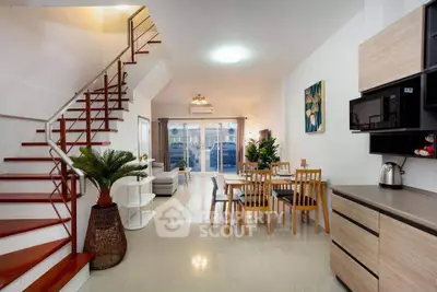 Spacious modern living room with open kitchen and stylish staircase