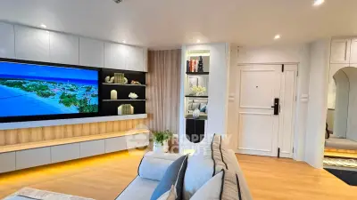 Modern living room with sleek design, large TV, and stylish shelving in a contemporary apartment.
