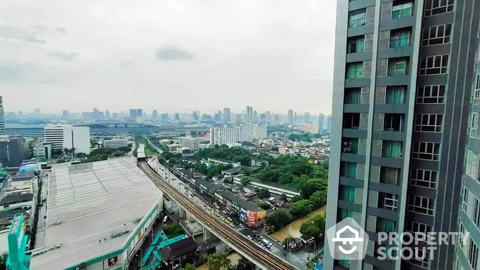 Stunning cityscape view from high-rise building showcasing urban skyline and lush greenery.