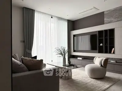 Modern living room with elegant decor and large TV, featuring a cozy seating area and stylish curtains.