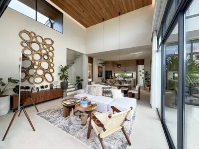 Luxurious modern living room with high ceilings, stylish decor, and abundant natural light.