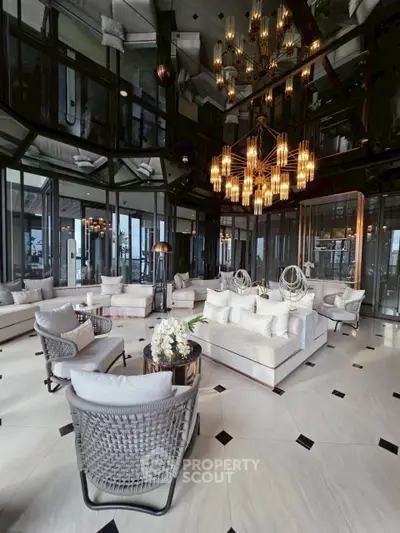 Luxurious modern living room with elegant chandelier and plush seating in high-rise building.