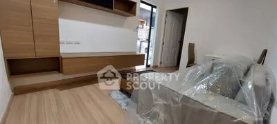 Modern living room with wooden flooring and sleek furniture in a cozy apartment.