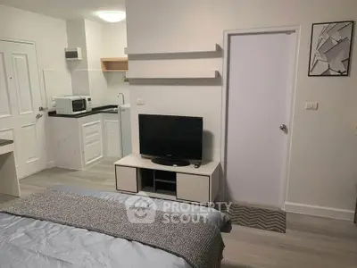 Modern studio apartment with sleek design, featuring a cozy bed, compact kitchen, and stylish decor.