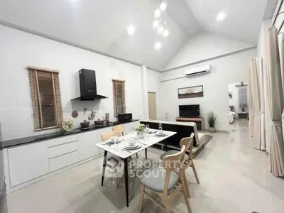 Spacious open-plan kitchen and dining area with modern decor and high ceilings.