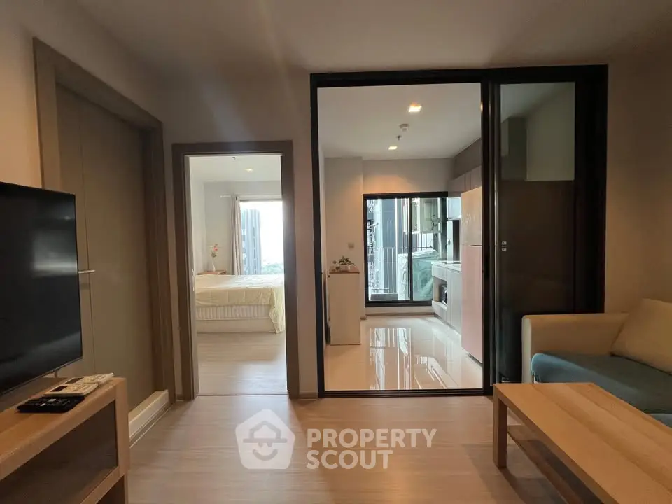Modern apartment interior with open living room, cozy bedroom, and sleek kitchen design.