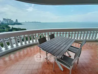 Stunning balcony with panoramic ocean view and outdoor dining setup.