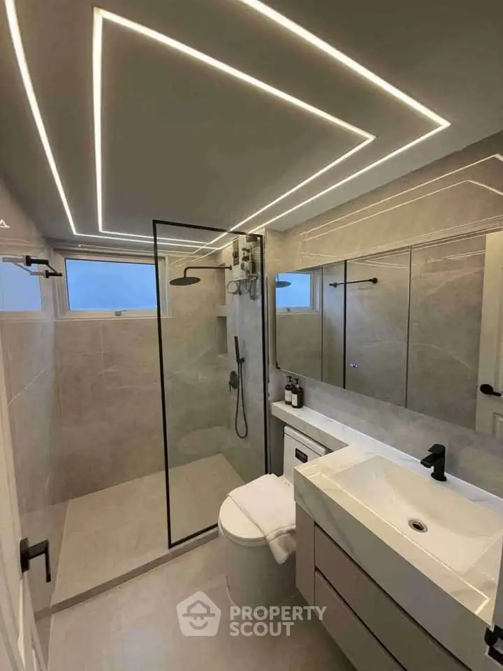 Modern bathroom with sleek design, glass shower, and elegant lighting