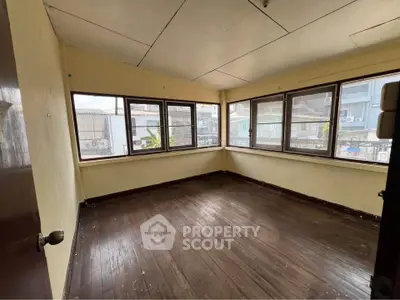 Spacious corner unit with large windows and wooden flooring, offering ample natural light and a cozy atmosphere.
