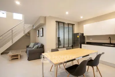 Modern open-plan living room and kitchen with sleek design and ample natural light.