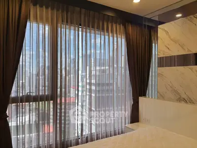 Luxurious bedroom with stunning city view through elegant sheer curtains.
