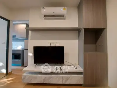 Modern living room with TV, air conditioning, and stylish shelving in a contemporary apartment.