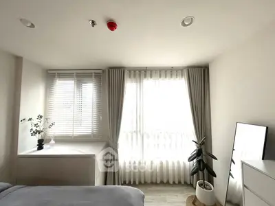 Bright bedroom with large windows, modern decor, and natural light.