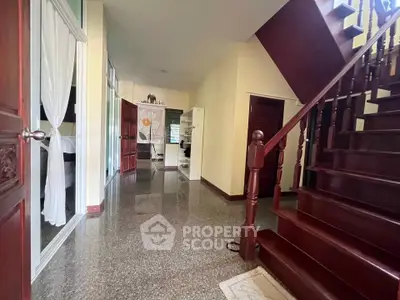 Spacious hallway with elegant wooden staircase and polished flooring in a modern home.