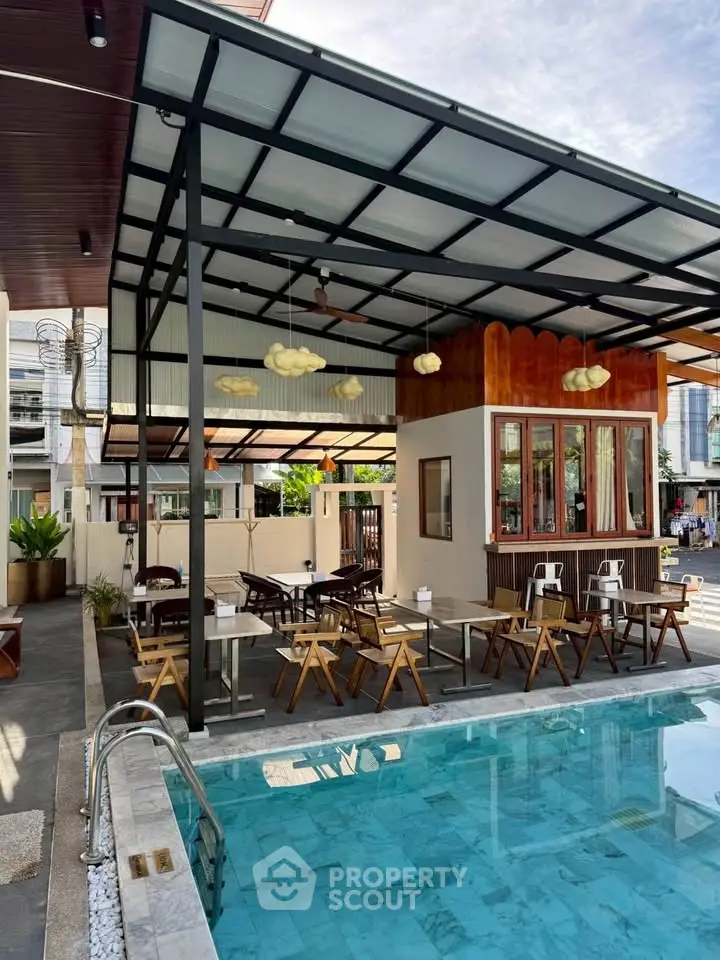 Chic outdoor pool area with modern seating and stylish pergola, perfect for relaxation and entertainment.