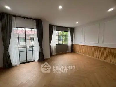 Spacious empty room with large windows and elegant curtains, perfect for customization.