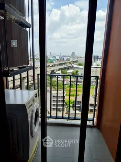 High-rise balcony with city view and washing machine, perfect for urban living.