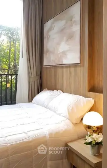 Cozy bedroom with elegant decor and natural light, featuring a stylish painting and a serene view.