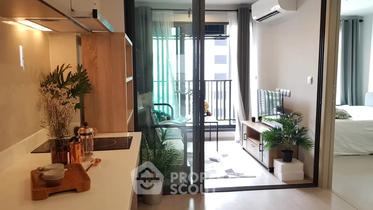 Modern open-plan living room with balcony and stylish kitchen in a contemporary apartment.