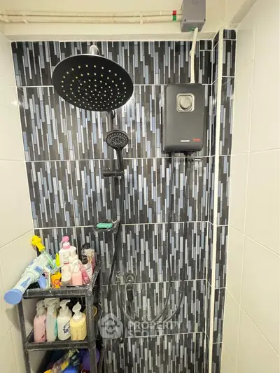 Modern bathroom shower area with stylish black and white tiles and storage shelves.