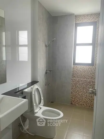 Modern bathroom with sleek design and natural light from large window.