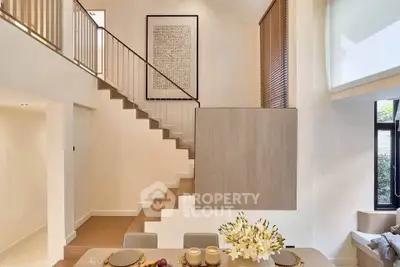 Elegant modern living room with high ceiling and stylish staircase, perfect for contemporary living.
