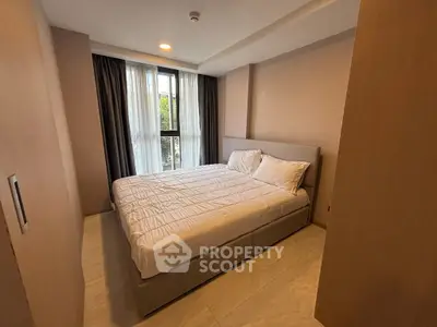 Cozy bedroom with natural light and modern furnishings in a stylish apartment.