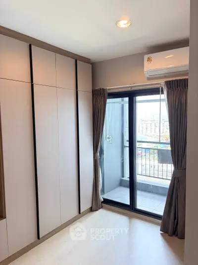 Modern bedroom with built-in wardrobe and balcony view in urban apartment