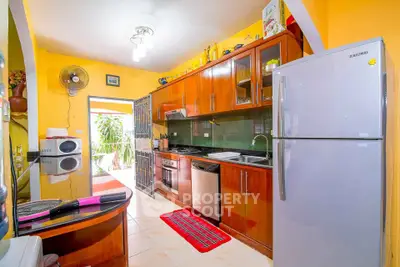 Vibrant kitchen with wooden cabinets, modern appliances, and colorful decor in a cozy home setting.