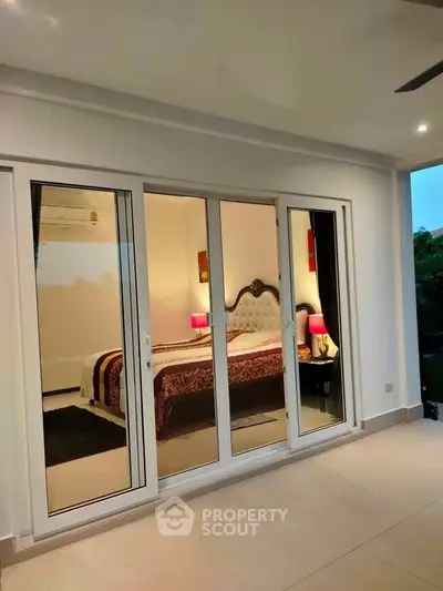 Luxurious bedroom with elegant decor and large sliding glass doors opening to a serene outdoor space.